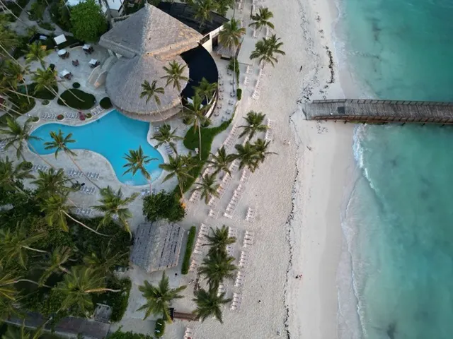Vista aérea de un resort con piscina y muelle junto al mar