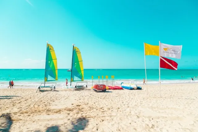 Veleros de playa y banderas sobre arena clara