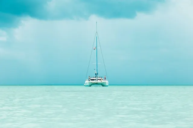 Catamarán navegando en aguas turquesa tranquilas